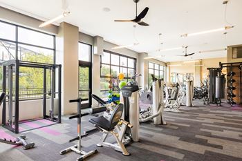 a gym with treadmills and other exercise equipment in a building with large windows at The Chase at Bryant Street, District of Columbia, 20002